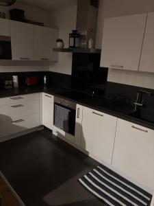 Una cocina con gabinetes blancos y un horno de estufa. en Maison 6 personnes à proximité Clermont-Fd, en Ceyrat