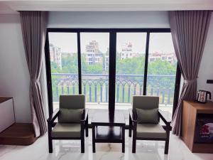 a room with two chairs and a table and a large window at 阮黄酒店 in Hòa Ðình