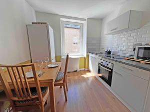 a kitchen with a table and chairs and a kitchen with a counter at Cosy appartement, Nancy center in Nancy +8 photos