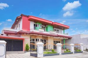 a colorful house with a fence in front of it at Collection O near Universitas Negeri Padang formerly Hotel Amra in Padang