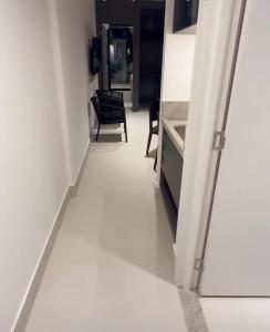 a hallway with a white floor and a chair at Porto 2 Life Resort in Porto De Galinhas