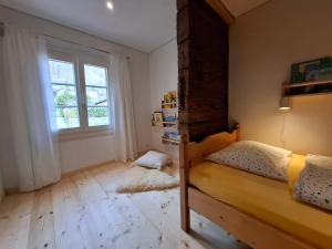 ein Schlafzimmer mit Etagenbett und Fenster in der Unterkunft Mattishüüsli - Chalet with a little garden in Luchsingen