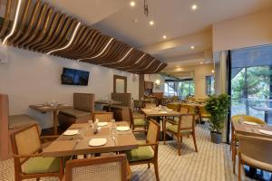 a restaurant with tables and chairs and a large window at Galaxy Beacon Hotel, Santacruz ,Mumbai in Mumbai