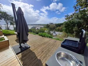 a bathroom with a sink and an umbrella on a deck at Maison de charme cancalaise in Cancale