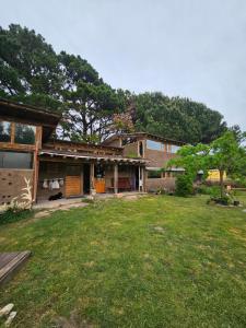 a house with a green yard in front of it at Jardin de Epicuro in Colonia Chapadmalal