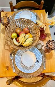a table with plates and fruit in a basket at Executive Tamarind Nest in Ukunda