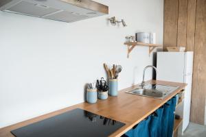 a kitchen with a sink and a refrigerator at Loft avec filet d'habitation suspendu géant proche mer in Bouin