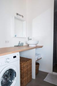 a bathroom with a washing machine and a sink at Loft avec filet d'habitation suspendu géant proche mer in Bouin