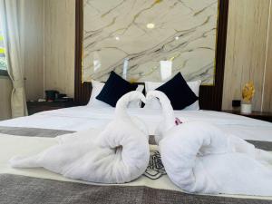 two swans shaped like swans sitting on a bed at Real Bungalow in Koh Rong