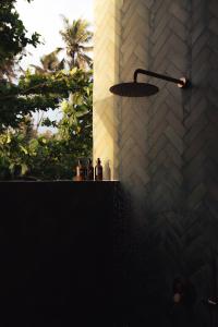 a light fixture hanging from a brick wall at UNU Boutique Hotel -- Adults Only -- in Ahangama