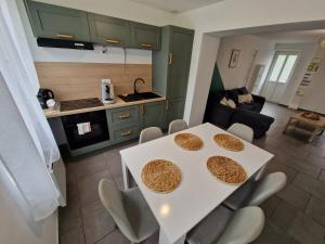 a kitchen and a living room with a table and chairs at Spacieux 3 chambres Tout équipé in Feignies