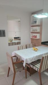 a dining room with a white table and chairs at Apartamento para Sammer Fest 2026 in Blumenau