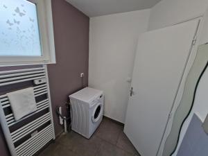 a small bathroom with a washing machine and a window at Spacieux 3 chambres Tout équipé in Feignies