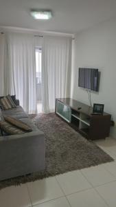 a living room with a couch and a flat screen tv at Apartamento para Sammer Fest 2026 in Blumenau