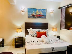 a bedroom with a large bed with two lamps at Executive Tamarind Nest in Ukunda