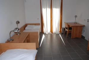 a room with two beds and a desk and a table at Szent Jakab Vendégház in Pannonhalma +8 photos