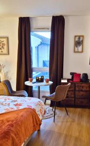 a bedroom with a bed and a table and a window at L'Ambre - Moderne - Equipé - Douche in Lourdes