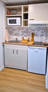 a kitchen with white cabinets and a counter top at L'Ambre - Moderne - Equipé - Douche in Lourdes