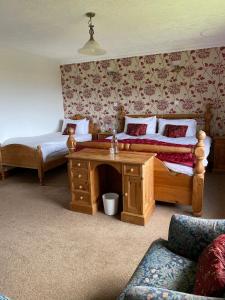 een slaapkamer met twee bedden, een tafel en een bank bij Abalone Accommodation in Culbokie