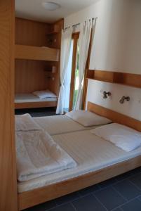 a bedroom with two bunk beds and a window at Szent Jakab Vendégház in Pannonhalma