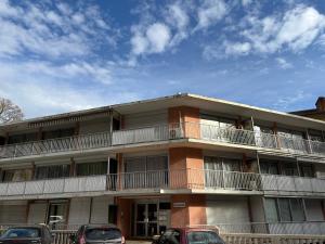 ein Mehrfamilienhaus mit davor geparkten Autos in der Unterkunft T2 proche Thermes Vals Idéal curistes et familles in Vals-les-Bains