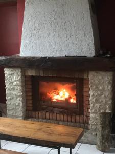 a fireplace with a wooden bench in front of it at La Fermette Aux Lamas in Savigny-Lévescault +27 photos