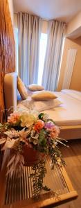 1 Schlafzimmer mit 2 Betten mit Blumen auf dem Tisch in der Unterkunft Infinity ApartHotel Boutique - Gym Roof Top & Spa in Mamaia Nord – Năvodari + 58 Fotos