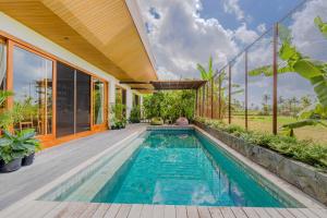 an indoor swimming pool in a house with windows at The Vinaya Boutique Hotel in Ubud
