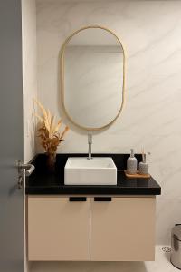 un baño con lavabo y espejo en Flat Praia do Bessa, en João Pessoa