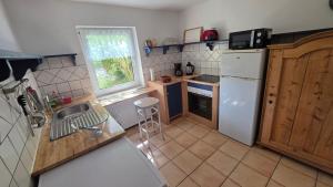 une cuisine avec un réfrigérateur blanc et un évier dans l'établissement Haus am See Zislow Whg 2, à Zislow