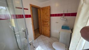 La salle de bains est pourvue d'une douche, de toilettes et d'une porte. dans l'établissement Haus am See Zislow Whg 2, à Zislow 4 autres photos