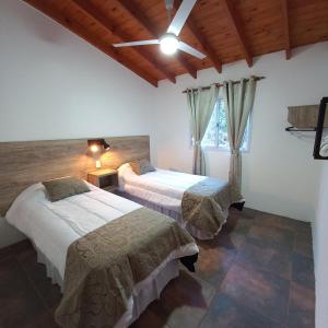 a bedroom with two beds and a window at Don Andrés y doña cuca in Merlo