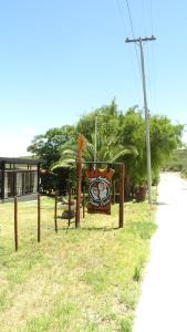 a sign in the grass next to a street at Don Andrés y doña cuca in Merlo