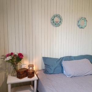 a bed with a blue pillow and a table with flowers at Mary Elena in La Porteña