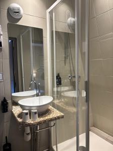 a bathroom with a sink and a glass shower at Korner République in Paris
