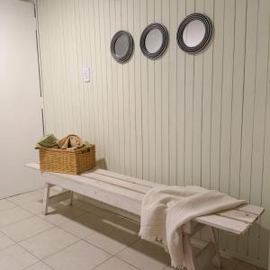 a bench with a basket and three plates on the wall at Mary Elena in La Porteña