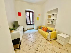 a living room with a yellow couch and a desk at Sardinian Gallery Corso in Bosa
