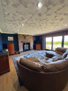 een woonkamer met een bank en een open haard bij Abalone Accommodation in Culbokie