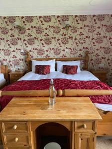 een slaapkamer met een bed en een houten tafel bij Abalone Accommodation in Culbokie