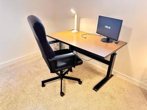 ein Schreibtisch mit einem Computermonitor und einem schwarzen Stuhl in der Unterkunft Cozy and Spacious Suite in a Pet and Smoke free Home - Self checkin Anytime - Private Ensuit Bath - King Bed - Ultra Fast Wifi - Free Parking - Smart TV in Rockland