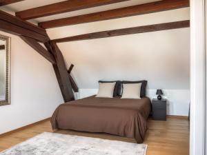 a bedroom with a bed in a room with wooden ceilings at Résidence 90 m2 lumineuse - cour intérieure alsacienne, balcon & parking in Marlenheim