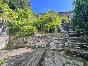 a small child standing next to a stone wall at Maison de charme cancalaise in Cancale