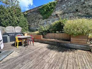 a patio with a table and chairs on a wooden deck at Maison de charme cancalaise in Cancale
