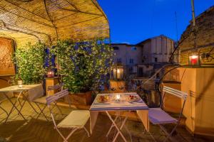 a table and chairs on a patio with a view of a city at The Inn at the Roman Forum Luxury Collection - The Inn At The Roman Forum in Rome