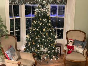een kerstboom in een woonkamer met een kerstman-ornament bij Luxury pair of Georgian apartments, hot tub, sea views, sleeps 12 in Bognor Regis