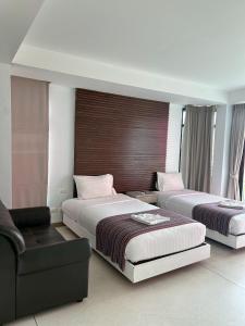 a hotel room with two beds and a couch at Coco boutique hotel in Patong Beach