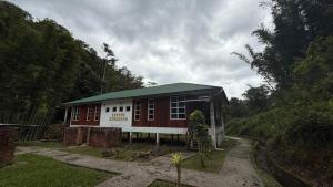 ein rotweißes Gebäude mit einem grünen Dach in der Unterkunft Mahua Lodge and Campsite in Tambunan