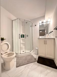 a white bathroom with a shower and a toilet at Cozy and Spacious Suite - Private Ensuit Bath - King Bed - Ultra Fast Wifi - Free Parking - Smart TV in Rockland