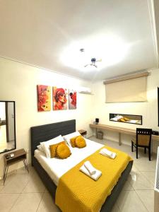 a bedroom with a large bed with a yellow blanket at Blue Port Beach House in Rafina