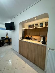 a kitchen with wooden cabinets and a dining room at Blue Port Beach House in Rafina